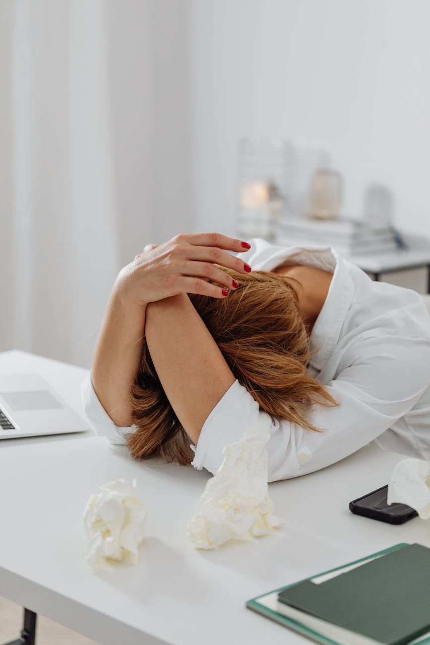a stressed woman leaning on white table